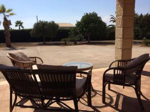 a patio with two chairs and a glass table at Villa Azzurra REITANI in San Lorenzo +4 photos