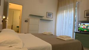 a bedroom with a bed and a flat screen tv at Hotel Ambassador Room Only - Self Check-in in Cattolica