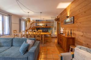 un salon avec un canapé bleu et une salle à manger dans l'établissement Chaleureuse Fruitière – 8 personnes, à Samoëns