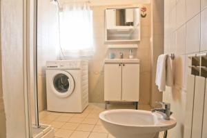un bagno con lavatrice e lavandino di Parcheggio gratuito vicino alla Torre di Pisa a Pisa