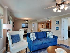 a living room with a blue couch and white chairs at Perdido Towers #604 in Perdido Key