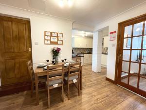 a kitchen and dining room with a wooden table and chairs at Lavender Cottage in Keswick
