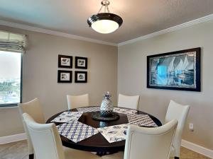 a dining room with a black table and white chairs at Perdido Towers #604 in Perdido Key +36 photos