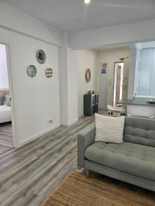 a living room with a couch and a kitchen at Estoril House in Estoril