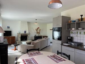 a kitchen and living room with couches and a fireplace at Le Village du Moulin in Sizun