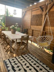 un patio con tavolo, sedie e altalena di Maison pour 6 personnes avec jardin et piscine ad Artigues-près-Bordeaux
