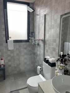 a bathroom with a toilet and a sink at Toes in the sand in São Roque +12 photos