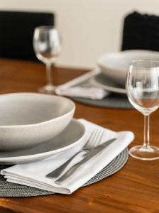 a table with white plates and silverware on a table at Elegant 3BD Seaside Villa With Sea View In Vari in Vari