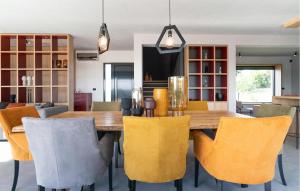 une salle à manger avec une table en bois et des chaises jaunes dans l'établissement Awesome Home In Bukori, à Baldaši