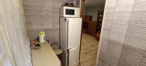 a kitchen with a refrigerator with a microwave on top of it at Old Town apartment in Narva