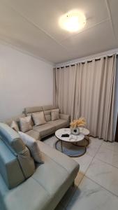 una sala de estar con un sofá y una mesa en NO LOADSHEDDING 1 Bedroom Apartment, en Trichardt
