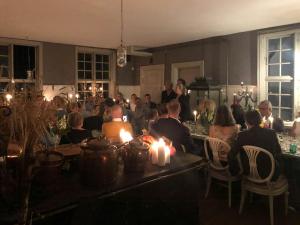 a group of people sitting at a table with candles at Historic Atmosphere At Gelskov Estate For You in Ringe