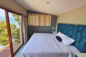 a bedroom with a bed and a large window at Quinta Sunrise, Lago de Coatepeque in El Congo +27 photos