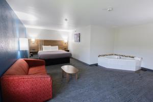 a hotel room with a bed and a couch and a tub at Countryside Inn and Suites in Mount Orab +23 photos
