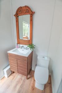 a bathroom with a toilet and a sink and a mirror at Highland Grand Canyon Glamping in Grand Canyon Village