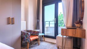 イスタンブールにあるAgion Living Taksim Cihangirの窓、椅子、テーブルが備わるベッドルーム1室が備わります。