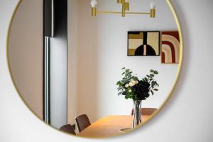 a table with a vase of flowers in a mirror at Stunning Luxury Townhouse in Centre of Manchester in Manchester