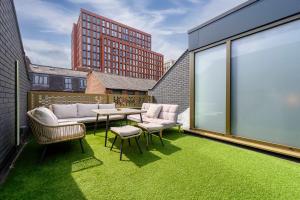 a balcony with green grass and a table and chairs at Stunning Luxury Townhouse in Centre of Manchester in Manchester +28 photos