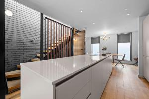 a kitchen with white cabinets and a brick wall at Stunning Luxury Townhouse in Centre of Manchester in Manchester