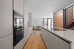 a kitchen with white cabinets and a counter top at Stunning Luxury Townhouse in Centre of Manchester in Manchester