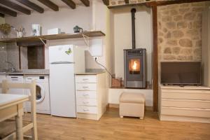 a kitchen with a white refrigerator and a stove at Casa rural La Bárcena Saja in Saja