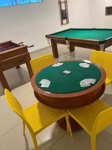 eine Tischtennisplatte mit zwei Stühlen und ein Billardtisch in der Unterkunft Caribbean Blue - Jardim Oceania in João Pessoa
