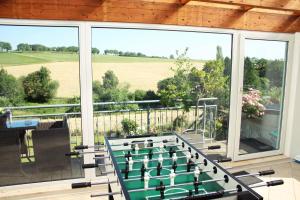 ein Balkon mit Blick auf ein Feld durch die Fenster in der Unterkunft Eifel-Ferienhaus Landblick in Hürtgenwald