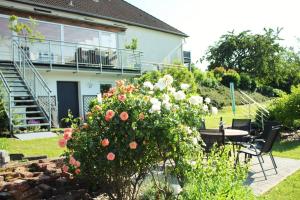 einen Garten mit einem Tisch und Blumen vor einem Haus in der Unterkunft Eifel-Ferienhaus Landblick in Hürtgenwald