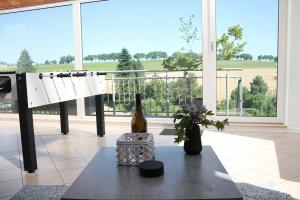 Zimmer mit einer Flasche Wein und einem Tisch in der Unterkunft Eifel-Ferienhaus Landblick in Hürtgenwald