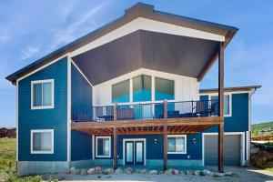 a blue and white house with a balcony at The Big Blue in Garden City