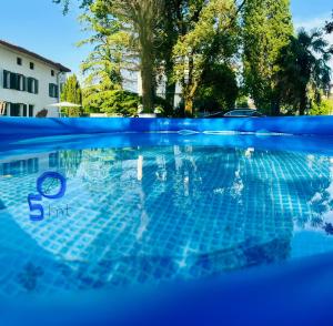 a blue swimming pool with a reflection in the water at Dori Affittacamere in San Lorenzo