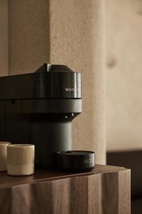 a coffee machine sitting on top of a table at Uzenie All Suites Boutique Resort - Adults Only in Adelianos Kampos