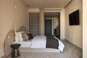 a bedroom with a large white bed in a room at Uzenie All Suites Boutique Resort - Adults Only in Adelianos Kampos