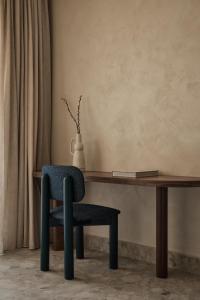 a chair sitting at a wooden desk with a vase at Uzenie All Suites Boutique Resort - Adults Only in Adelianos Kampos +132 photos