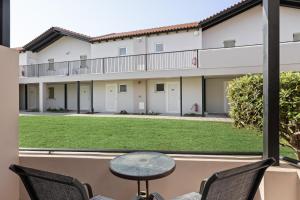 a patio with a table and chairs in front of a building at White Olive Marine Aquapark in Tigaki