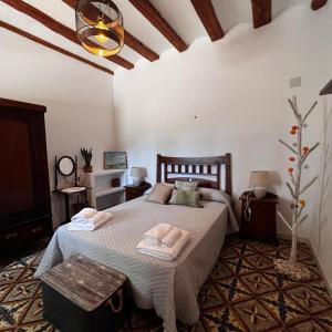 a bedroom with a bed with two towels on it at Masía El Sombrial de San Lorenzo in Alfafara