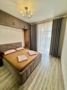 Un dormitorio con una cama grande y una ventana grande. en A-Six Apartament, ЖК Arman kala, en Karagandá