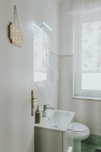 a white bathroom with a sink and a toilet at Shalom Portici in Portici