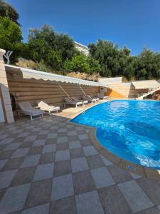 a large swimming pool with chairs at Valtos Ionion in Parga +22 photos