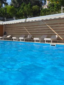 a large swimming pool with blue water and chairs at Valtos Ionion in Parga