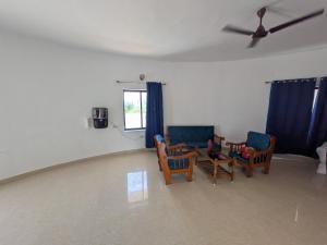 a living room with two chairs and a table at ANV Beach house in Kovakulam