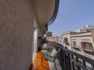 a balcony with two chairs and a view of a building at Domus Eterea in Marsala