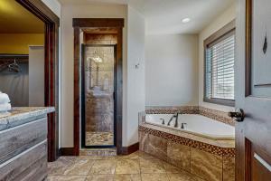 a bathroom with a tub and a shower at Heider Cabin in Garden City +26 photos