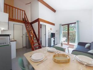 a living room with a table with plates on it at Holiday Home Les Charmilles-6 by Interhome in La Palmyre