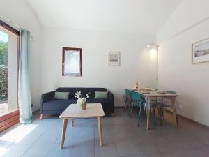 a living room with a couch and a table at Holiday Home Les Charmilles-6 by Interhome in La Palmyre +36 photos