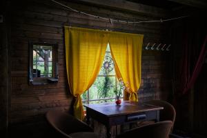 a table and chairs in a room with a window at Blickinsfreie - Cabin in Schöneck