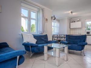 a living room with blue couches and a table at Holiday Home Domek Joanna-1 by Interhome in Łeba