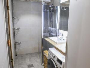 ein Badezimmer mit einer Dusche, einem Waschbecken und einer Waschmaschine in der Unterkunft Holiday Home Tunturikuksa by Interhome in Saariselkä