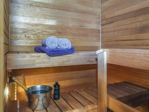 eine Sauna mit zwei Handtüchern auf einem Regal und einem Eimer in der Unterkunft Holiday Home Tunturikuksa by Interhome in Saariselkä + 12 Fotos