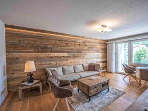 a living room with a couch and a wooden wall at Apartment Chesa Fleury by Interhome in St. Moritz